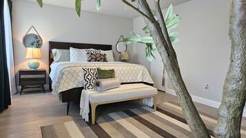 Une chambre à coucher avec un lit, des tables de chevet et un grand arbre artificiel.