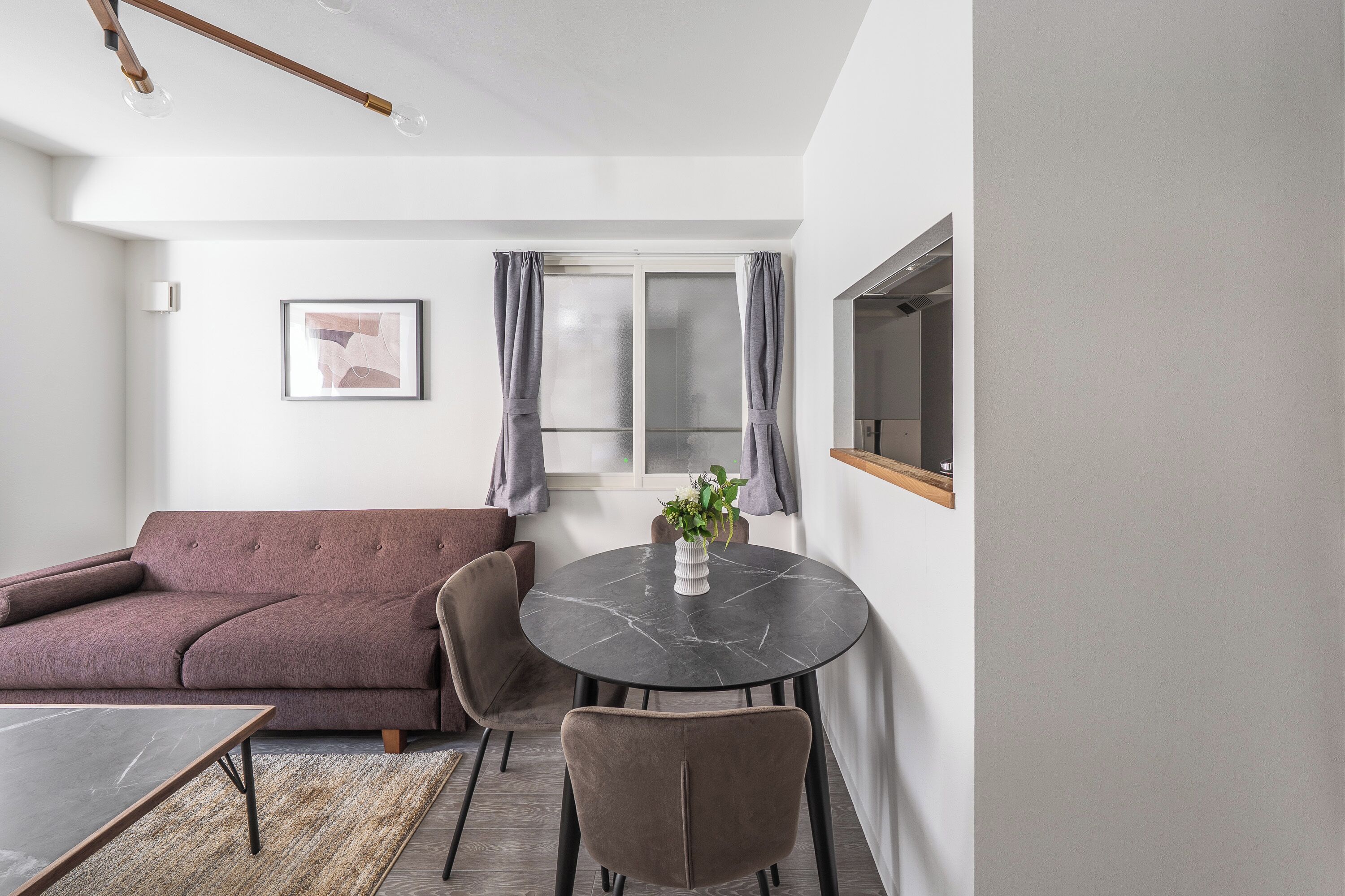 A modern living room with a sofa, a round table, and chairs.