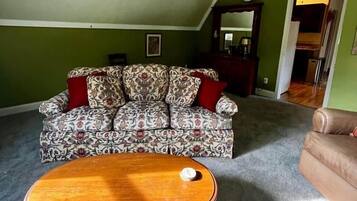 A living room with a patterned sofa, a wooden coffee table, and a ceiling fan.