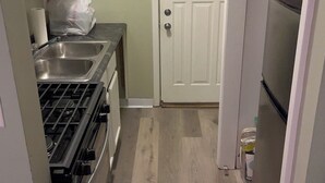 Une cuisine de taille réduite, équipée d’une cuisinière, d’un évier et d’un réfrigérateur.
