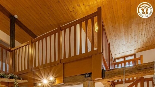 A spacious living area with a high ceiling, wooden beams, a sofa set, a glass coffee table, and a hanging chair. - Le Thiellet - SAINT USUGE (SAINT USUGE)