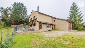 A stone house with a wooden porch and a small garden. - Le Thiellet - SAINT USUGE (SAINT USUGE)