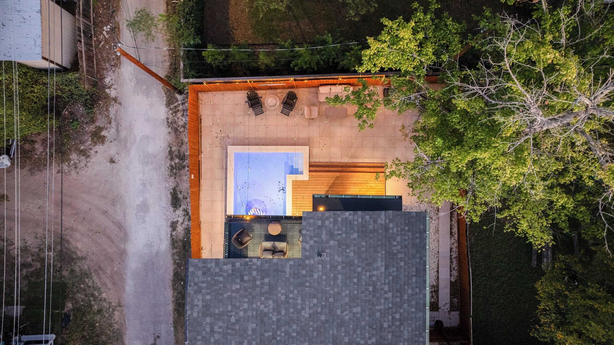 Vue aérienne d’une propriété dotée d’une piscine, d’un espace salon extérieur et d’une petite terrasse.