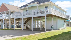 Ein zweistöckiges Haus mit überdachter Veranda, einer Treppe und einer Garage.