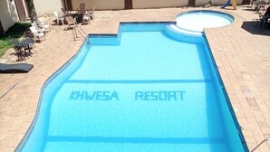 Uma piscina com a inscrição 'KHWE5A RESORT' na água.