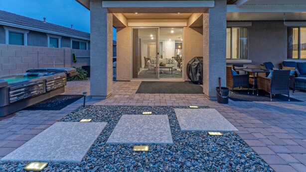 A modern outdoor patio area with a stone pathway, seating, and a barbecue grill. - Peaceful Location w/Sunset & Wildlife Views, Htd Pool, Hot Tub, Fire Table, 2 Bikes (Gold Canyon)