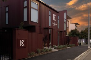 Un bâtiment moderne, orné d’un logo « K » bien visible, dont l’extérieur est bien entretenu, et qui se dresse sous un ciel dégagé.