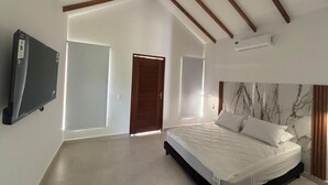 Ein Schlafzimmer mit Bett, Fernseher und Deckenventilator.