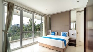 A modern hotel room with a large bed, a nightstand, and a view of a balcony.