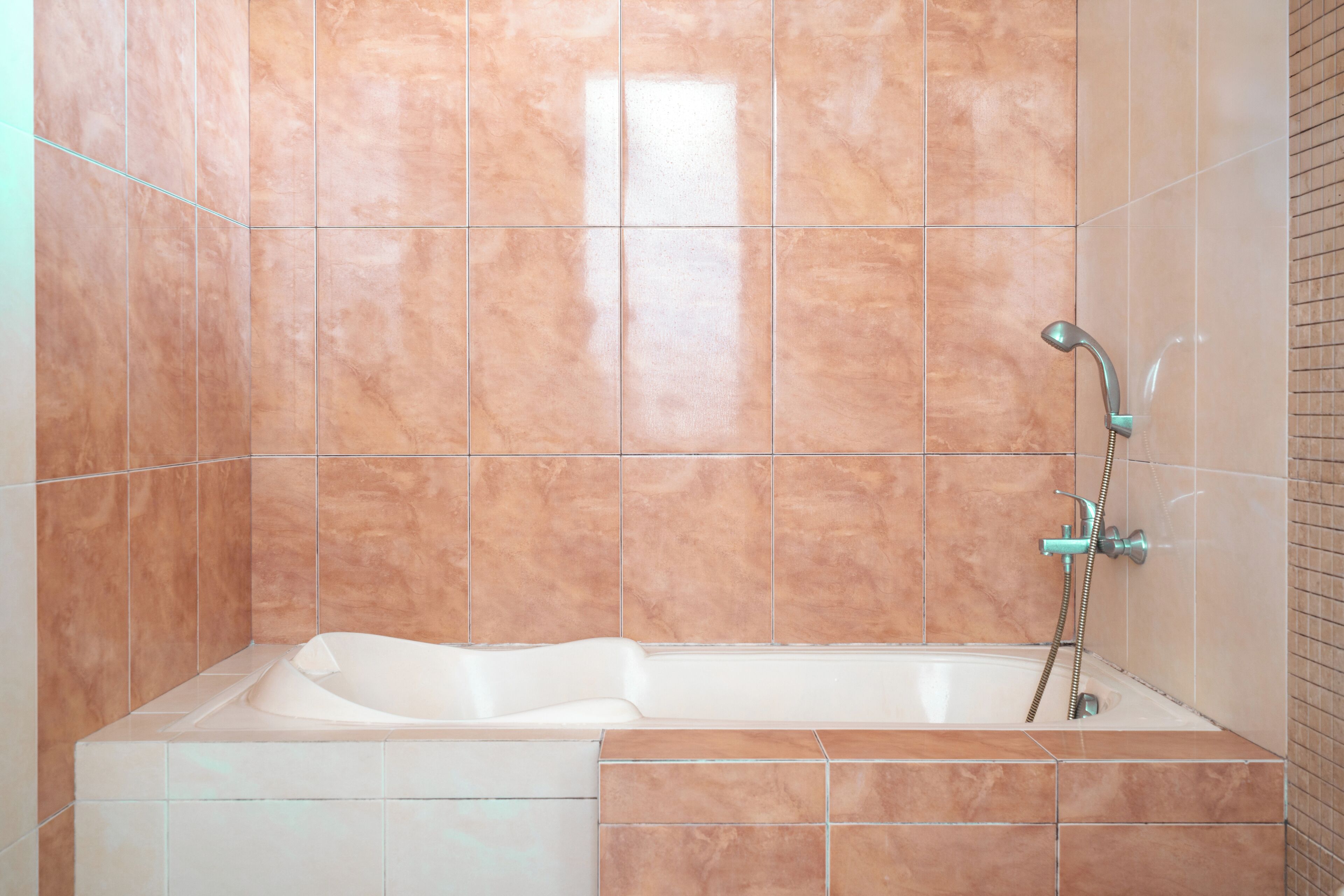 A bathroom with a bathtub, a shower, and tiled walls.