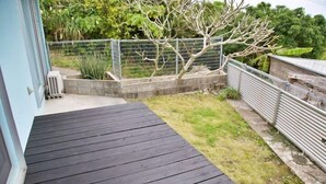Eine Holzterrasse mit Rasenfläche und einem umzäunten Garten.