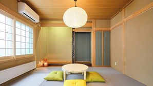 A traditional Japanese room with tatami flooring, a tatami mat table, and cushions. - Hoshiyado Asahikawa asahimachi (Asahikawa)