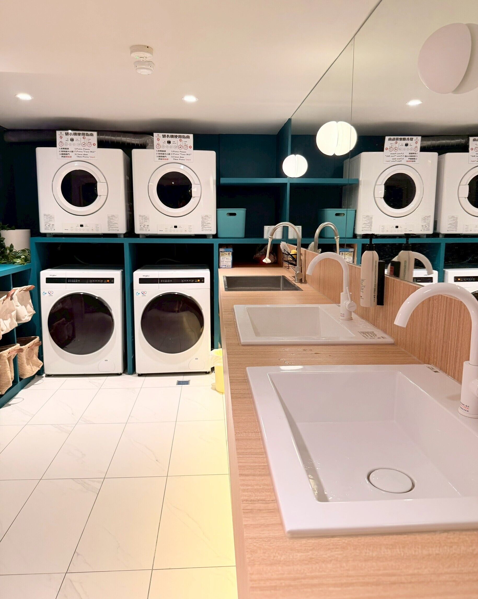 A laundry facility with multiple washing machines and sinks.