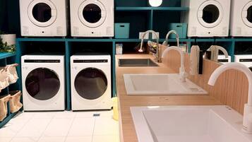 A laundry facility with multiple washing machines and sinks.