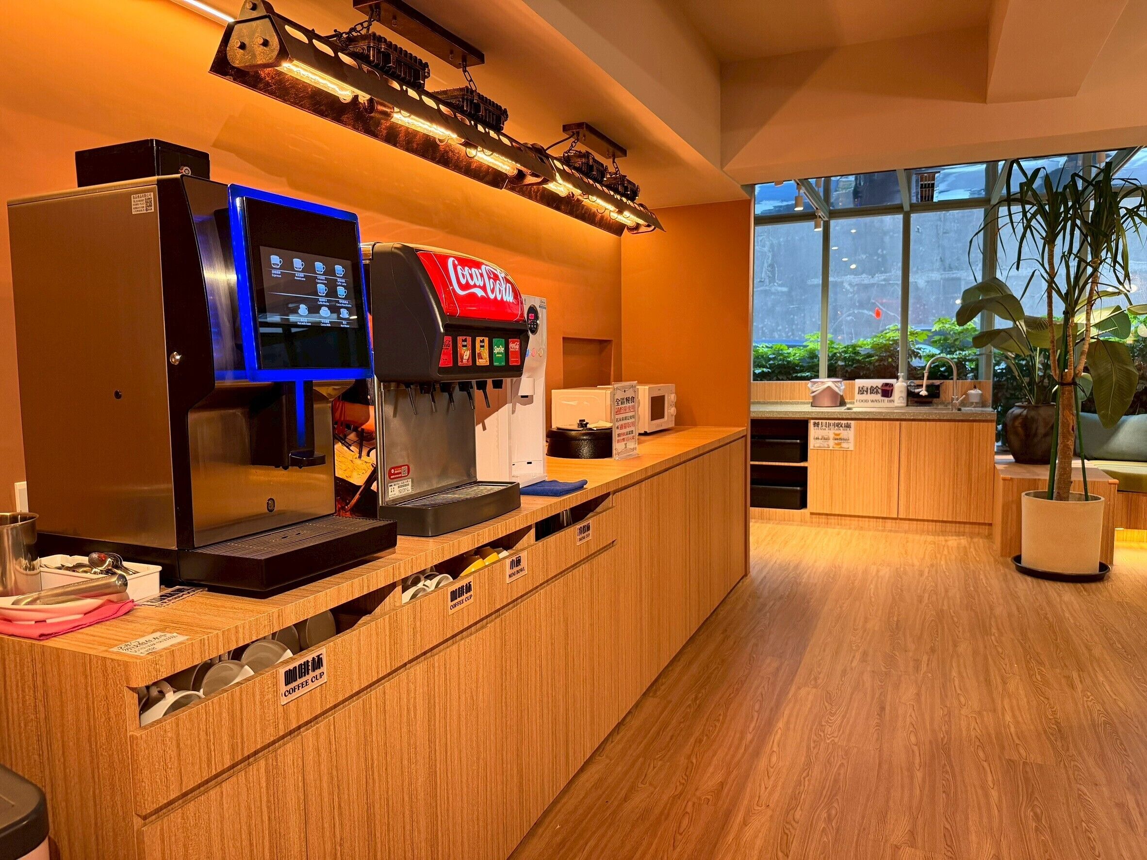 Un espace dédié au café, équipé d’un distributeur de Coca-Cola, d’une machine à café et d’un appareil numérique pour maintenir les tasses de café au chaud.
