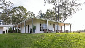 A two-story building with a covered porch and a lawn in front. - Bimbadgen Estate (Pokolbin)