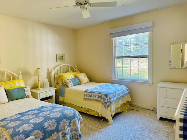 A bedroom with two beds, a window, a ceiling fan, and a dresser. - BayWatch: Chesapeake Bayfront Retreat with a Small Private Beach. Dog Friendly. (Reedville)