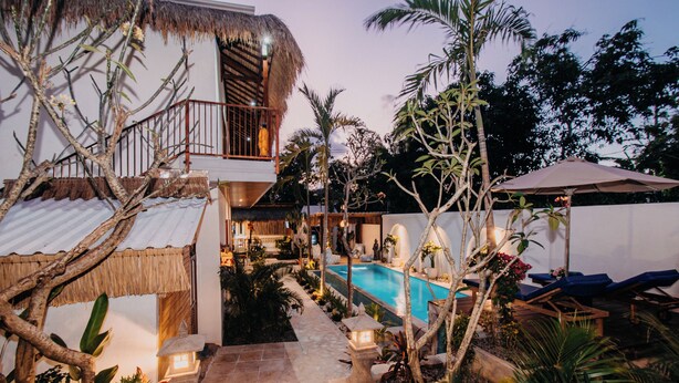A pool area with a thatched-roof structure, a staircase leading to a balcony, and lounge chairs around the pool. - 28 Degrees Lembongan (Lembongan Island)