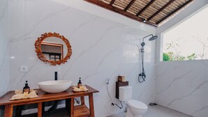A bathroom with a wooden vanity, a large mirror, a white sink, a toilet, and a shower. - 28 Degrees Lembongan (Lembongan Island)