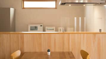 A modern kitchen with wooden cabinetry, a built-in microwave, and a stainless steel range hood.