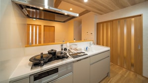 Una cucina moderna con una cappa in acciaio inossidabile, mobili in legno e pavimento in legno.