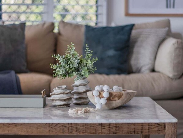 A wooden coffee table with a bowl of white eggs and a small potted plant. - Humpback Villa by Holiday Management Co. (Tweed)