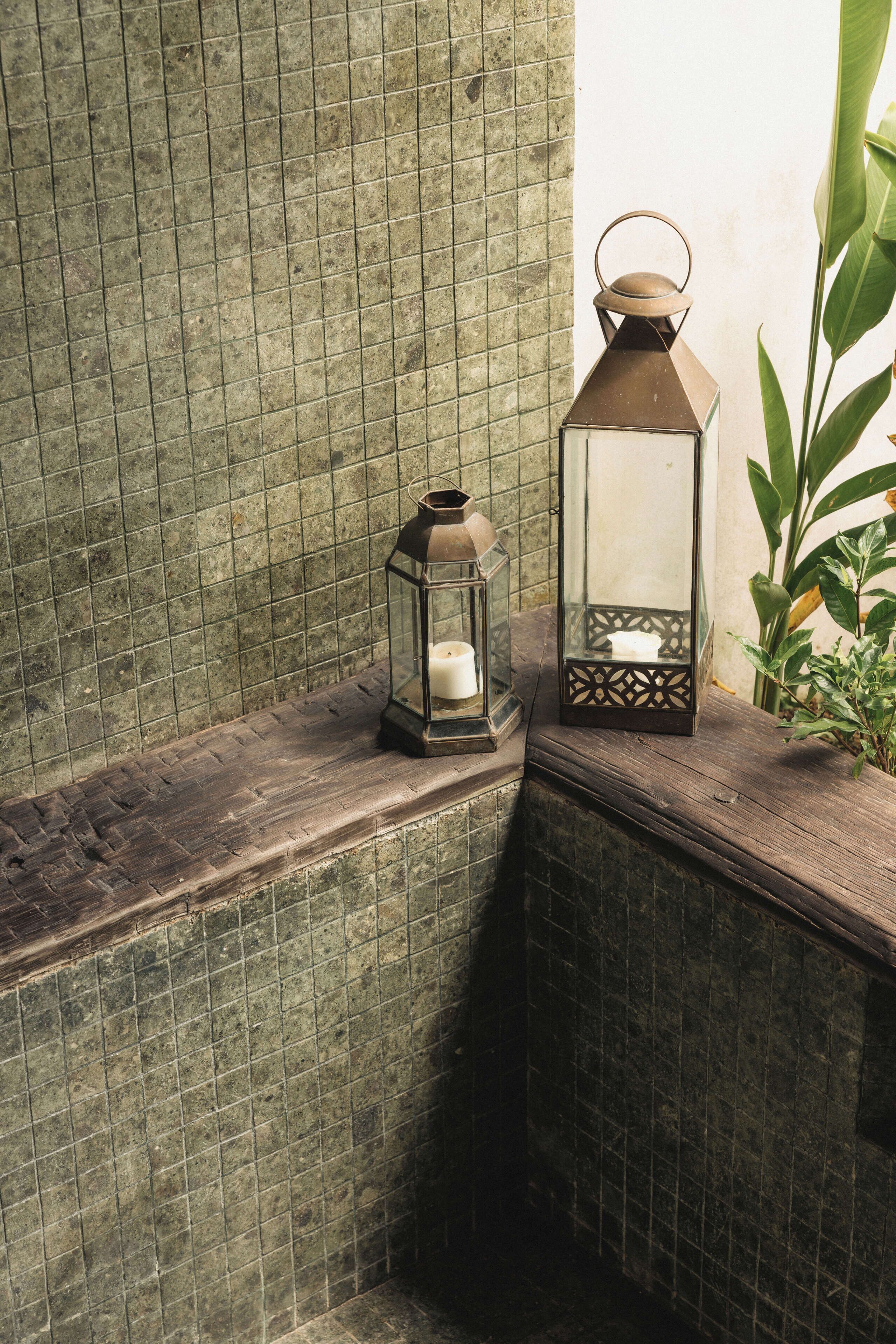 A corner with a wooden ledge, two lanterns, and a potted plant.