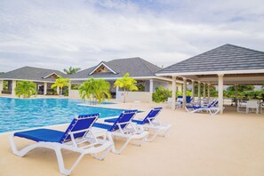 A pool area with lounge chairs and covered seating. - Cozy 3BR Villa w/ Poolside Gym, AC & WiFi near Ocho Rios (Ocho Rios)