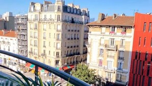 A multi-story building with balconies, a red building to the right, and a clear blue sky. - Chic Parisian Apartment - Air-Con, 1-Bed (Le Kremlin-Bicetre)