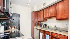Una cocina moderna con electrodomésticos de acero inoxidable, armarios de madera y encimera de granito.