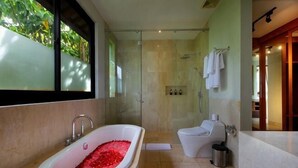 Een moderne badkamer met een vrijstaand bad, een douchecabine en een toilet.