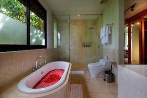 A modern bathroom with a freestanding bathtub, a shower enclosure, and a toilet. - Trisha Cliff Villa by Parigata (Bali)