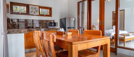 Eine moderne Küche mit Holztisch und -stühlen, einer Mikrowelle und einem Kühlschrank.