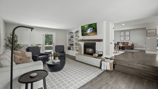 A modern living room with a fireplace, a television, and a sofa.
