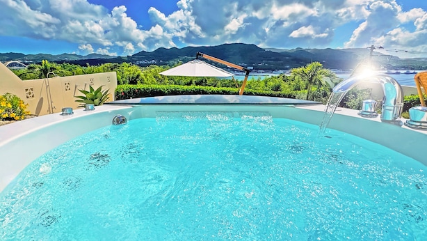 A swimming pool with a view of mountains and a white umbrella. - Resort Villa KAPUKA SESOKOJIMA (Motobu)