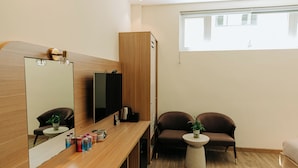 A modern bathroom with a wooden vanity, a large mirror, a sink, and two chairs. - An Mai Boutique (Lam Vien - Da Lat)