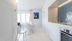 Een moderne keuken met witte kasten, een roestvrijstalen spoelbak en een ingebouwde oven.