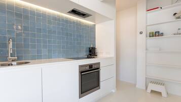 Een koelkast, een vaatwasser, kookgerei, borden en bestek