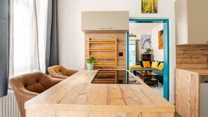 Een moderne woonkamer met een houten salontafel, een bank en een eethoek met stoelen.