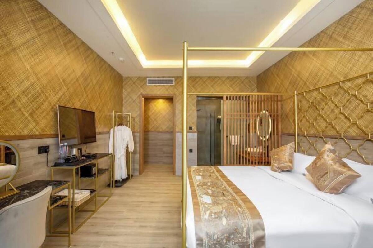 A modern hotel room with a large bed, a vanity with a mirror, and a walk-in closet.