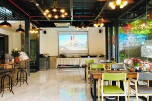 A conference room with a projector screen, tables, chairs, and a bar area. - Gongxingshe·Xichishanju homestay (Xingping Branch, Yangshuo) (Yangshuo)