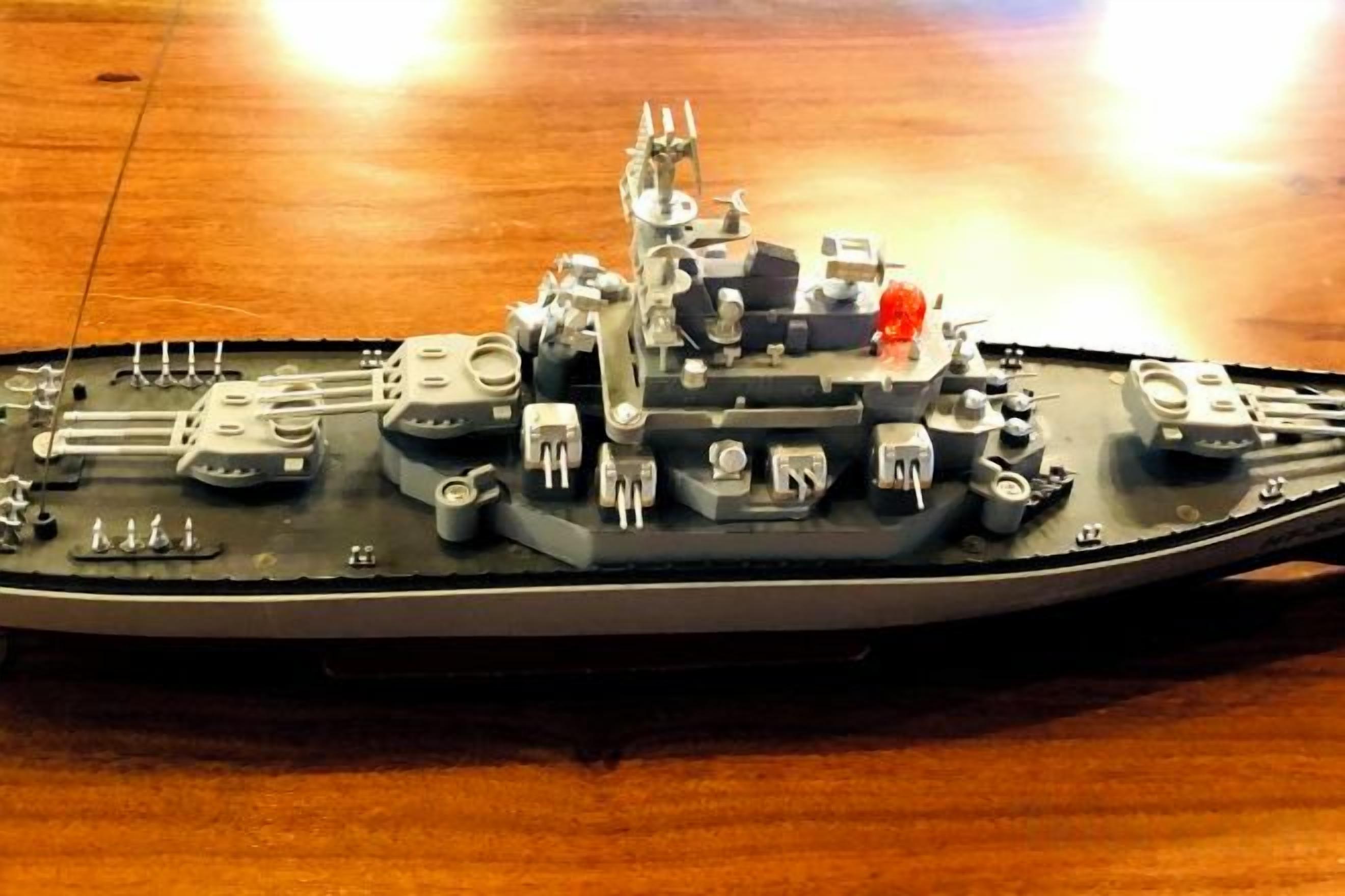 Een model schip met gedetailleerde dekindeling en diverse scheepscomponenten.