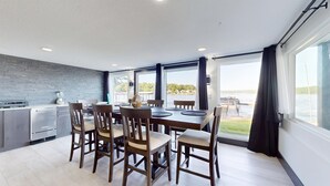 A modern kitchen with a dining area, large windows, and a view of the water. - Grandview Luxe Retreat - Gravois Arm (Gravois Mills)