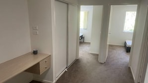 A hallway with a sliding door, a desk with drawers, and a carpeted floor. - Nice (Kuraby)
