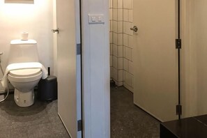 Ein Badezimmer mit Toilette, Waschbecken und Duschbereich.