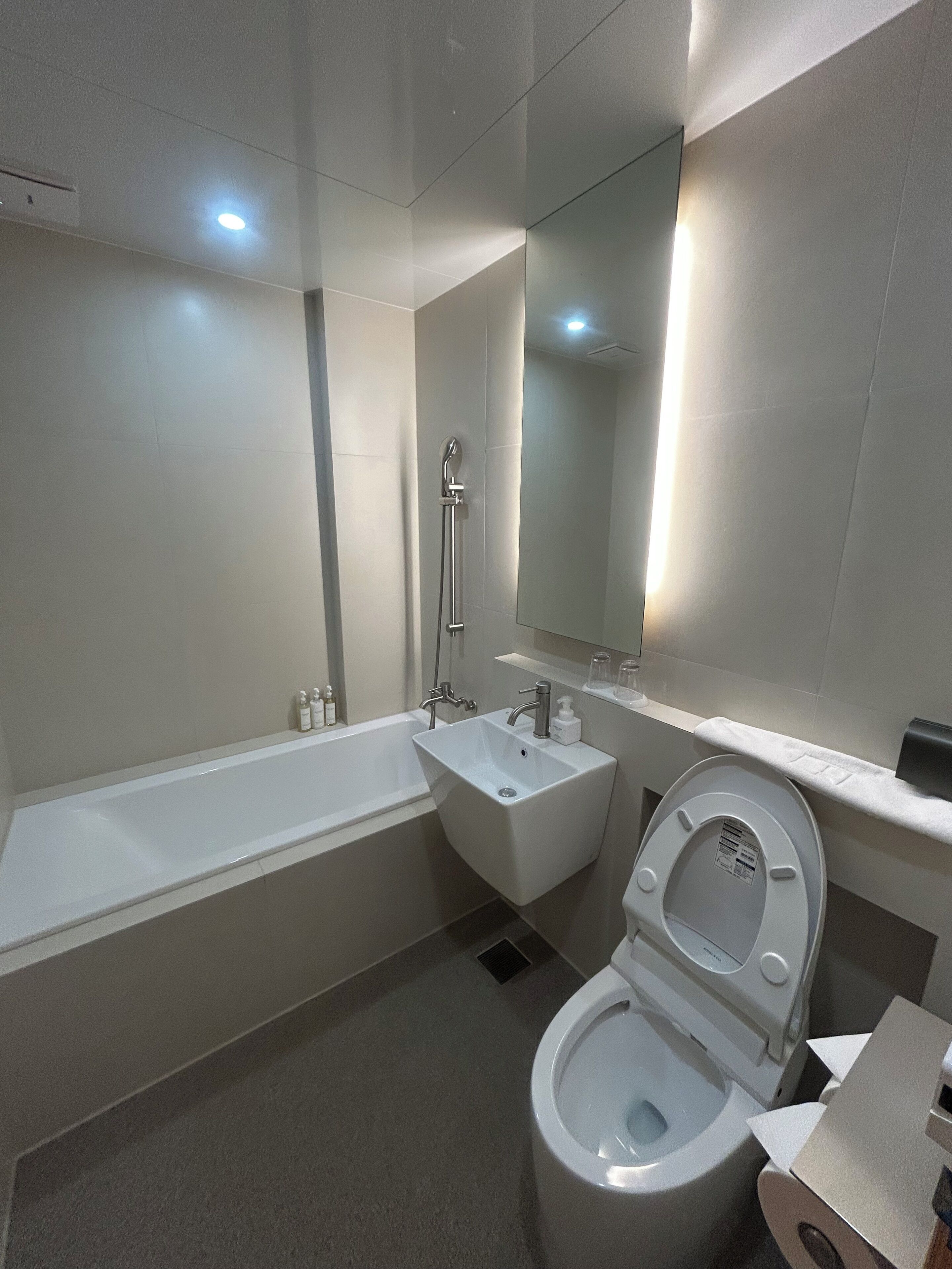 A modern bathroom with a bathtub, a sink, and a toilet.