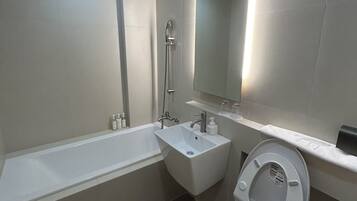 A modern bathroom with a bathtub, a sink, and a toilet.
