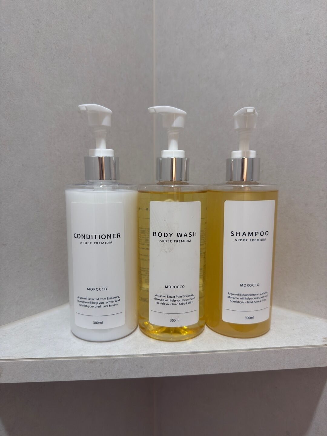 Trois bouteilles de produits de la gamme Arder Premium sont posées sur une étagère.