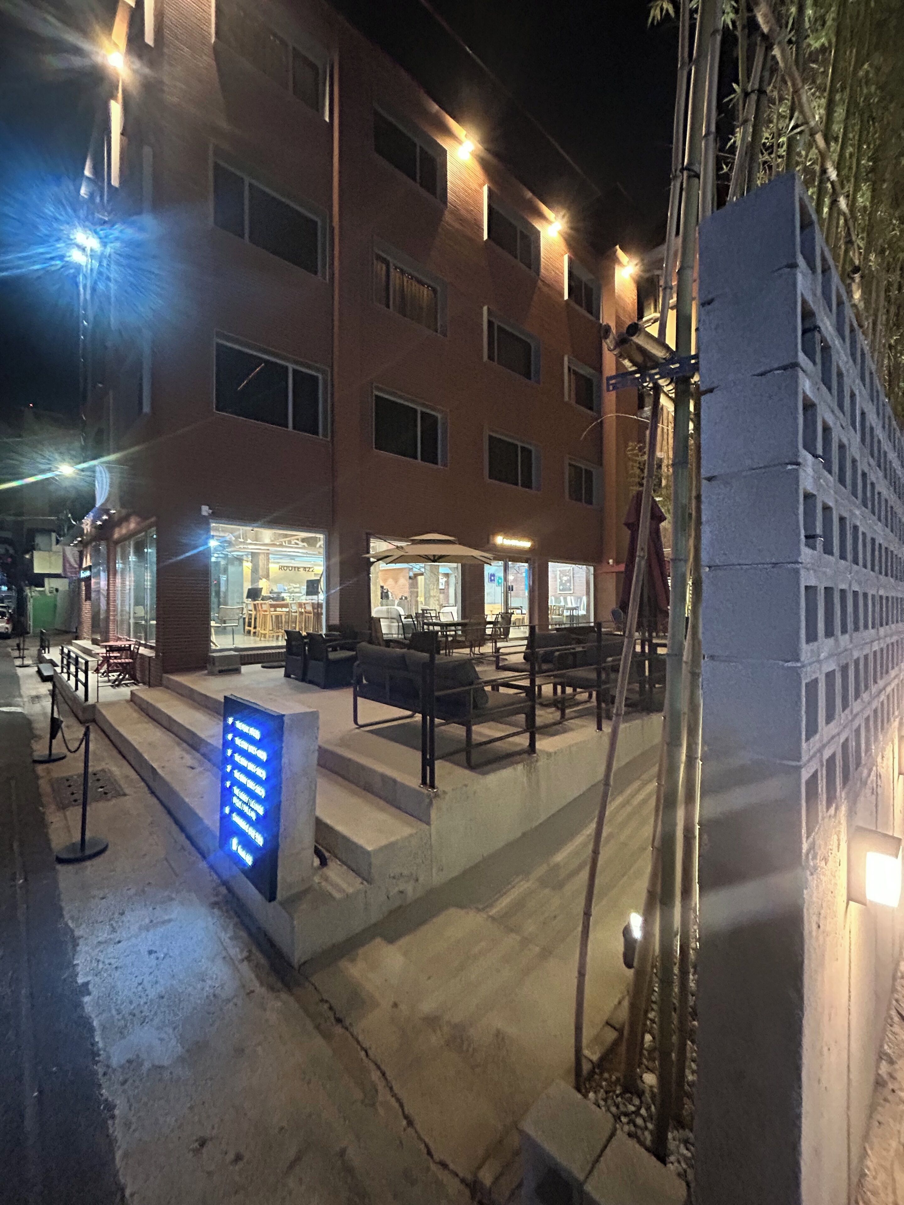 Un bâtiment doté de nombreuses fenêtres, d’une terrasse et d’une enseigne avec du texte.
