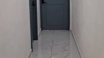 Un pasillo con una puerta cerrada marcada con una 'B' y un gráfico de girasol con el texto de bienvenida a The Bello Lodging.